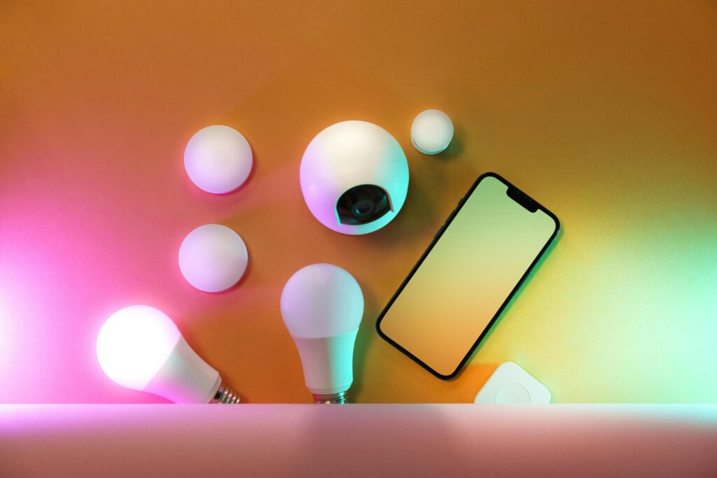 A collection of smart home devices including light bulbs and a smartphone, showcasing modern technology.